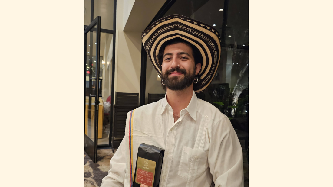 Camilo, dressed as in traditional Colombian attire, holds a bag of Santa Elena coffee