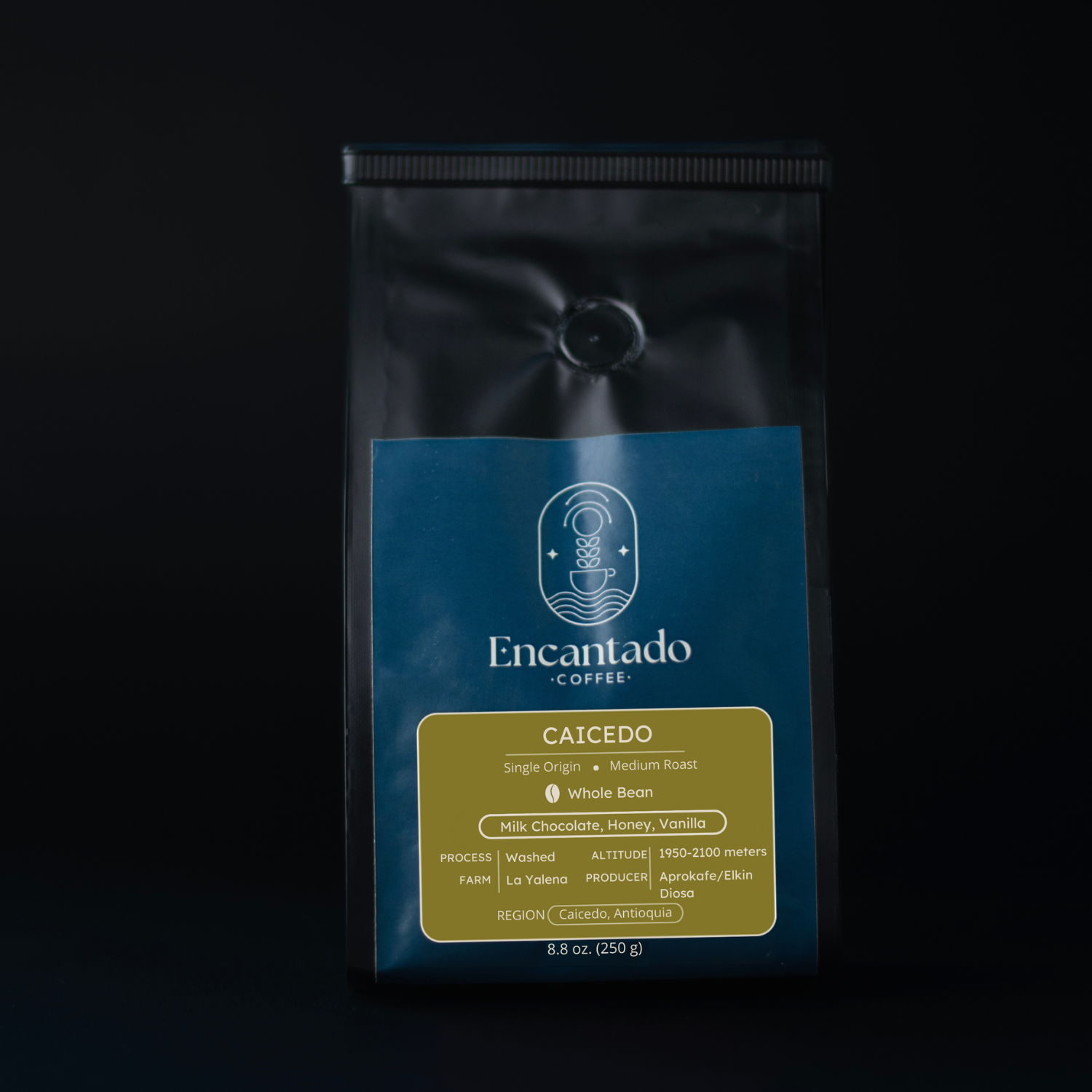 A bag of Caicedo coffee sits in front of a black background. It has a green and dark blue label.