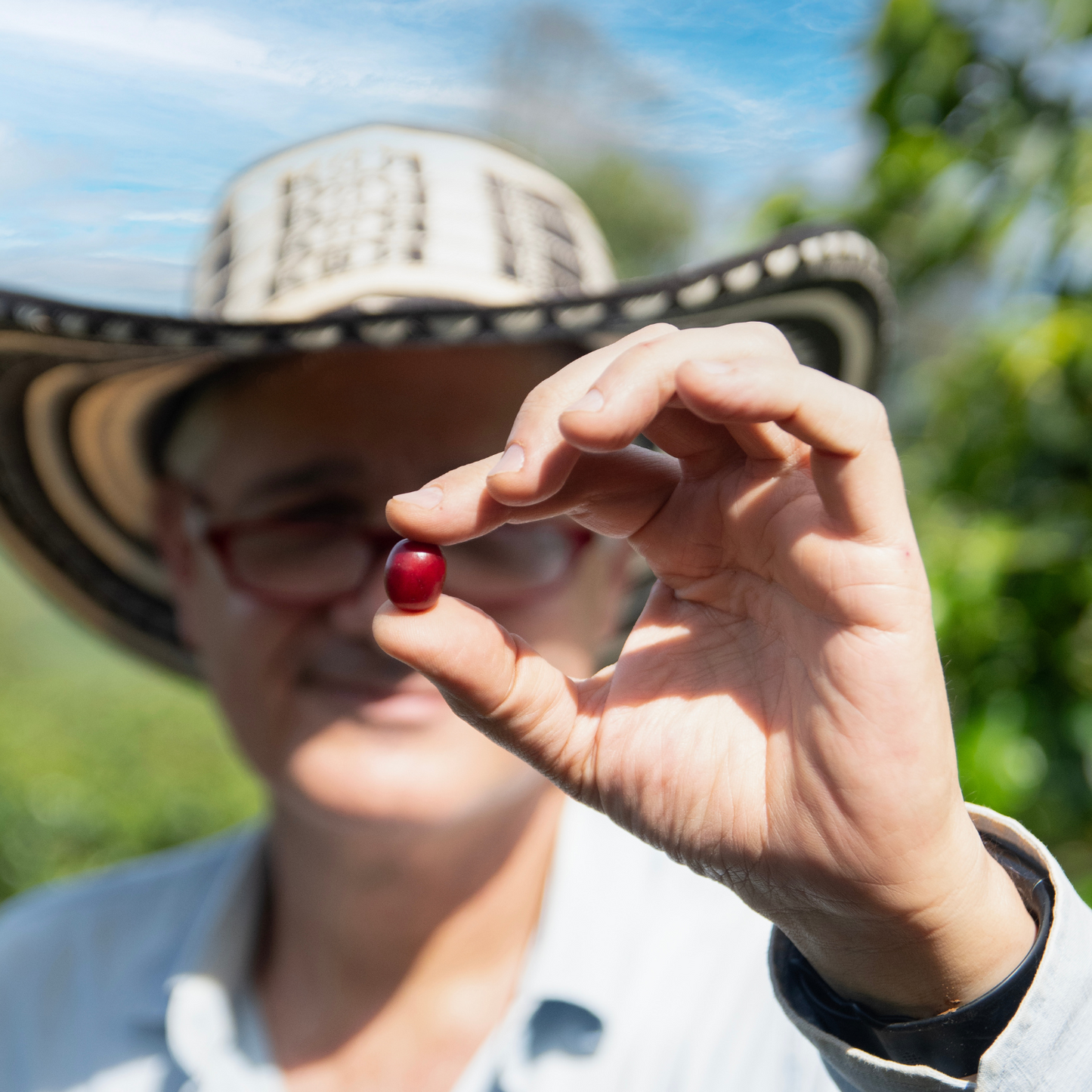 Samuel, a coffee farmer, holding a coffee cherry